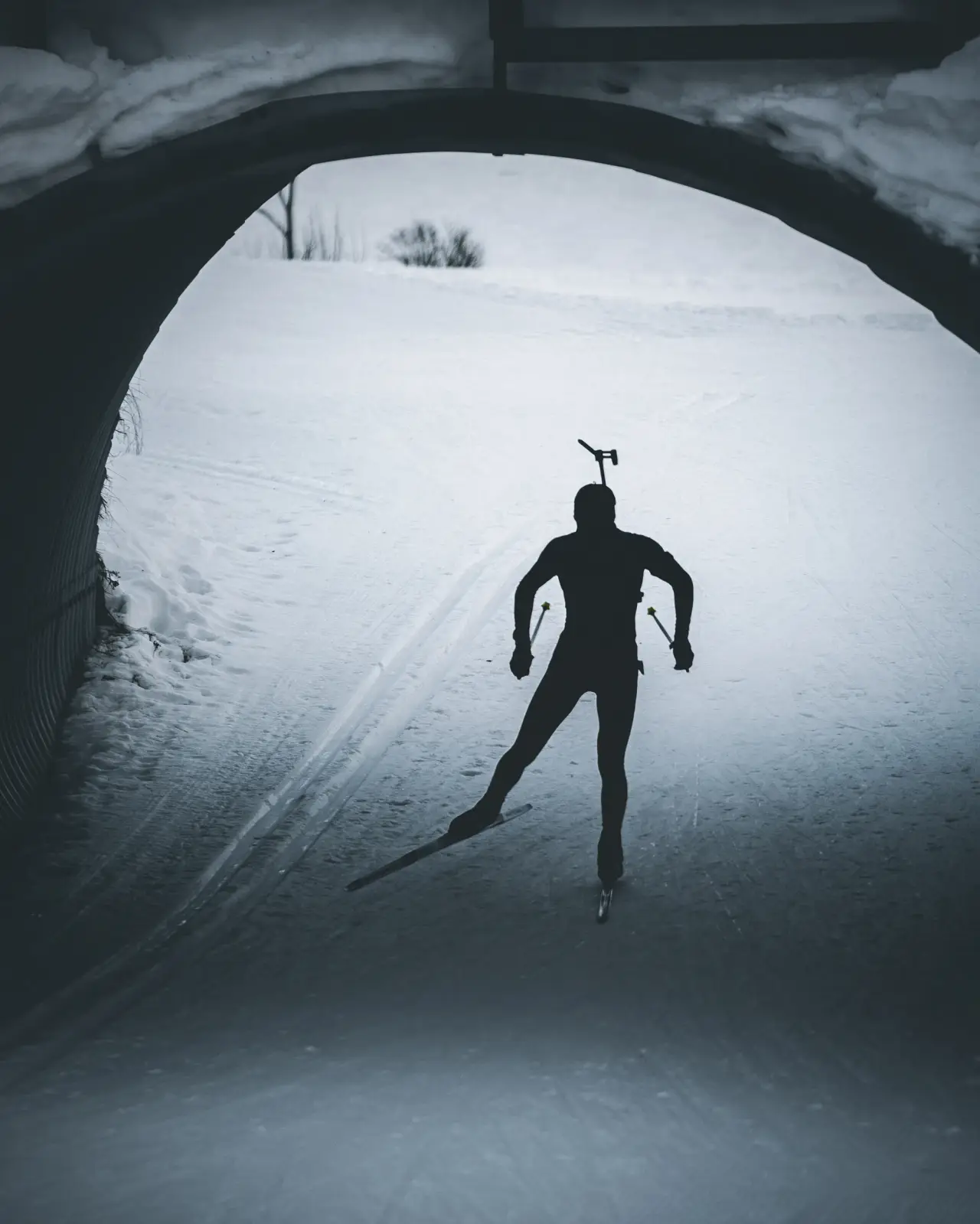 Skiskytter i silhuett i en skitunnel